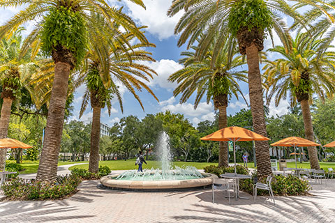 student walking by fountain on Coral Gables campus